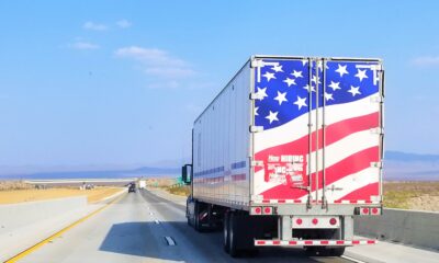 A Semi truck with the American Flag on the rear doors
