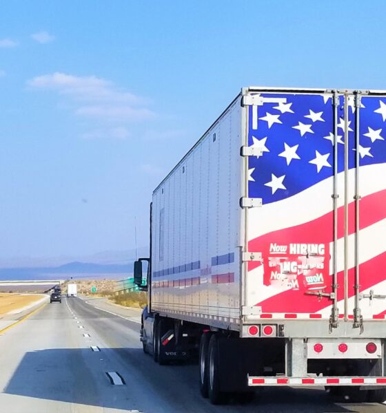 A Semi truck with the American Flag on the rear doors